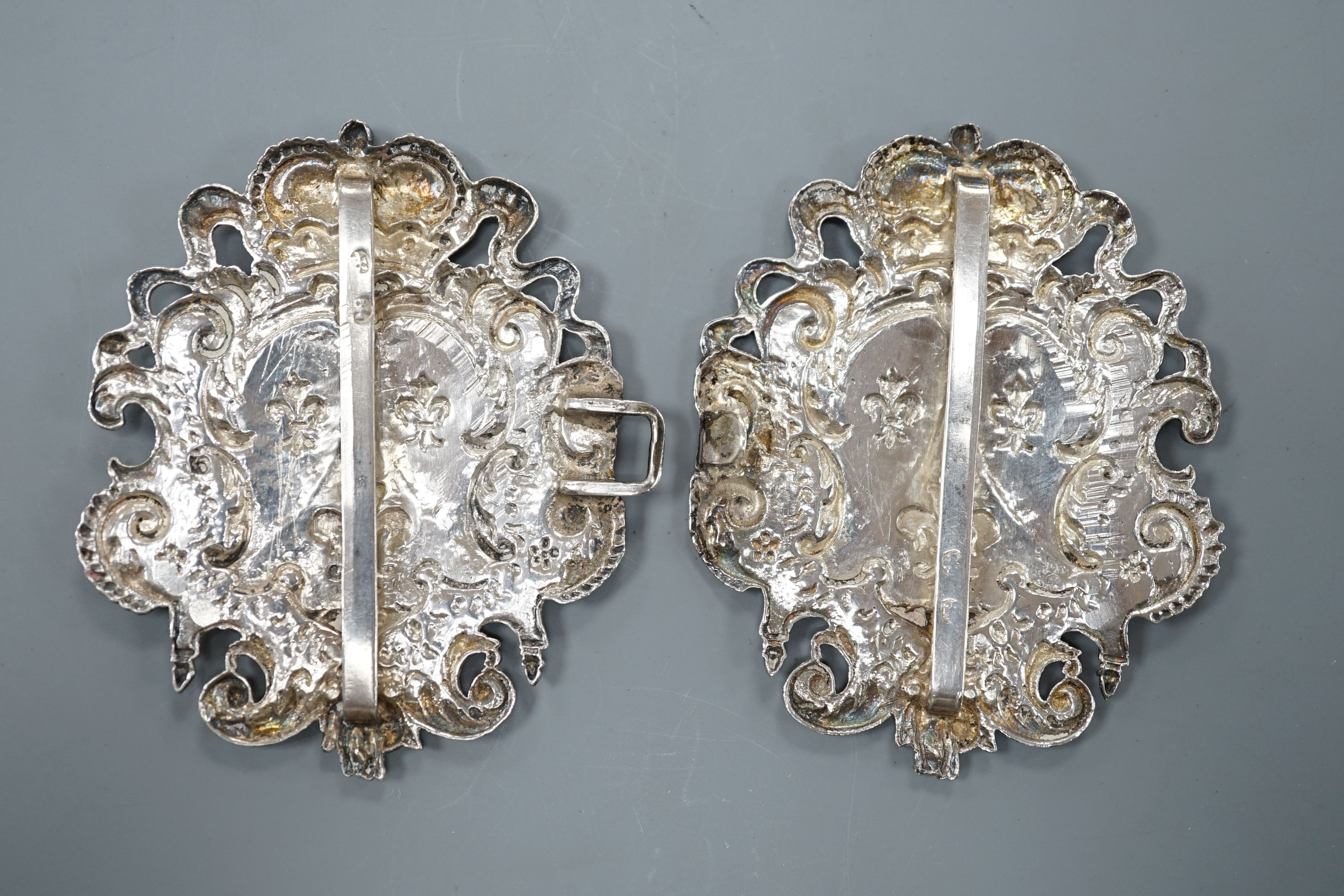 An 18th century Continental white metal belt buckle, modelled with the arms of the House of Bourbon and the Order of the Golden Fleece, height 7.5cm width overall 12cm, weight 66 grams